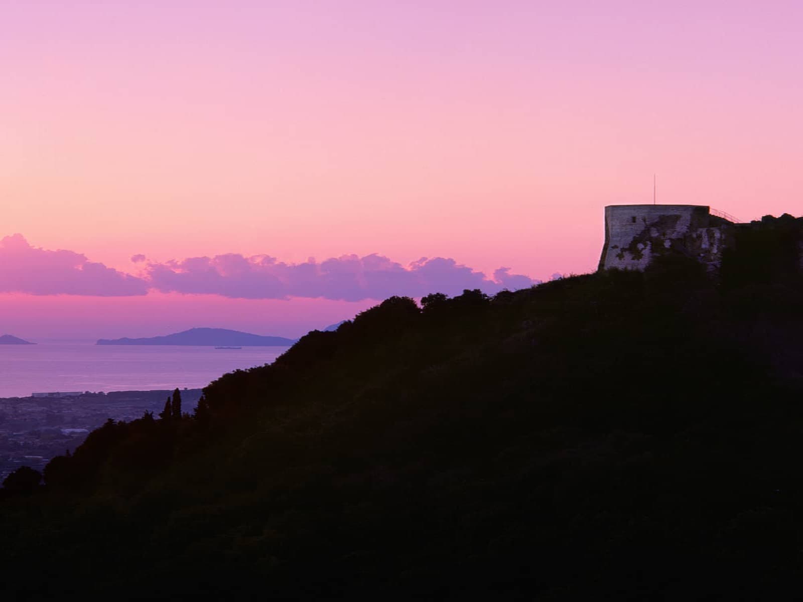 Vista del Castillo de Aghinolfi al atardecer, con el mar al fondo.