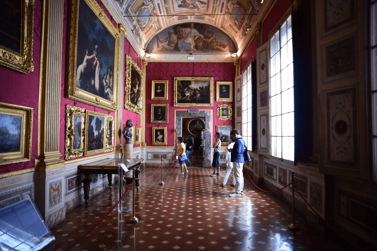 Sala di Palazzo Pitti con dipinti e visitatori