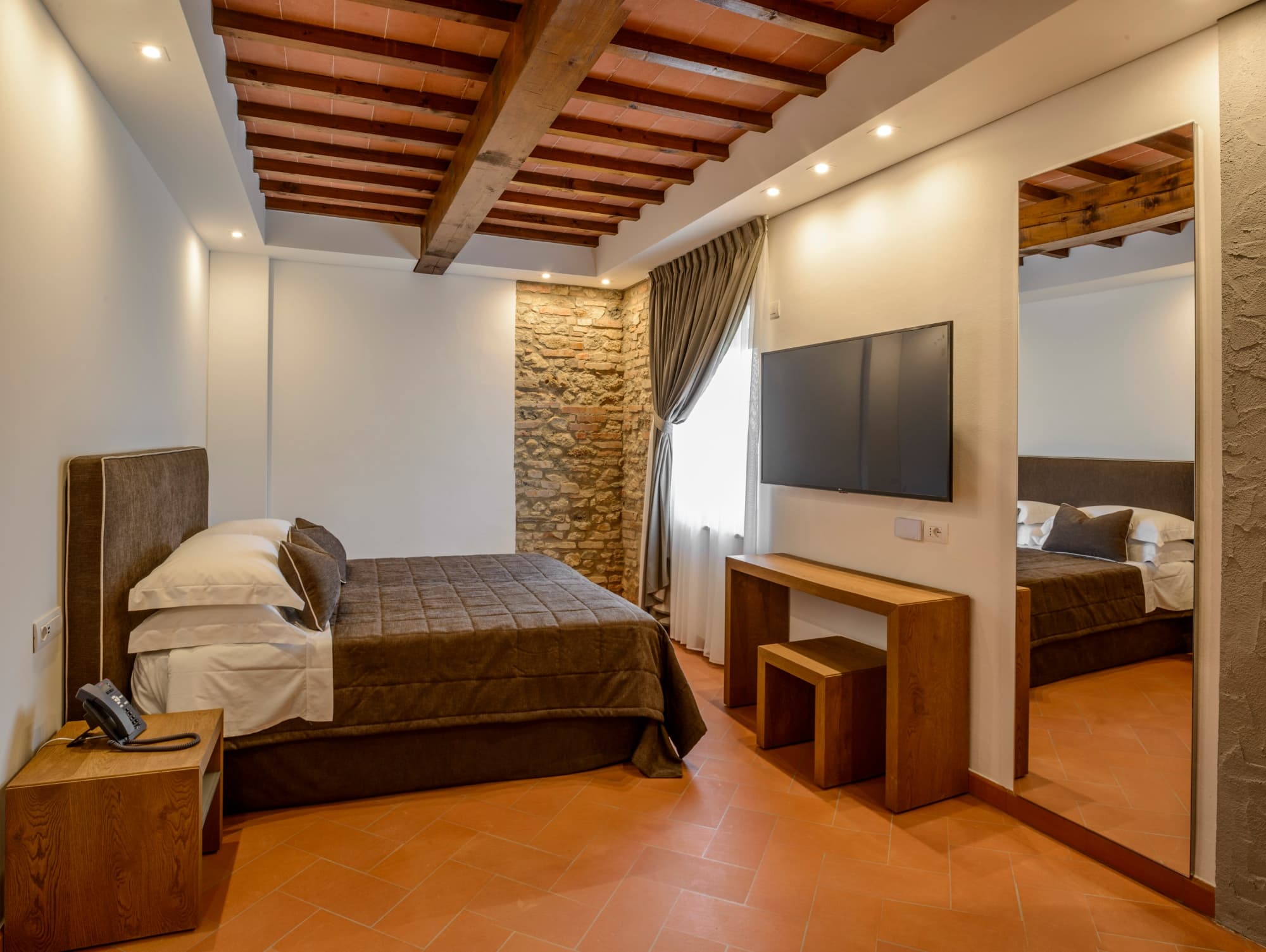 The bed of a double bedroom with exposed beam ceiling