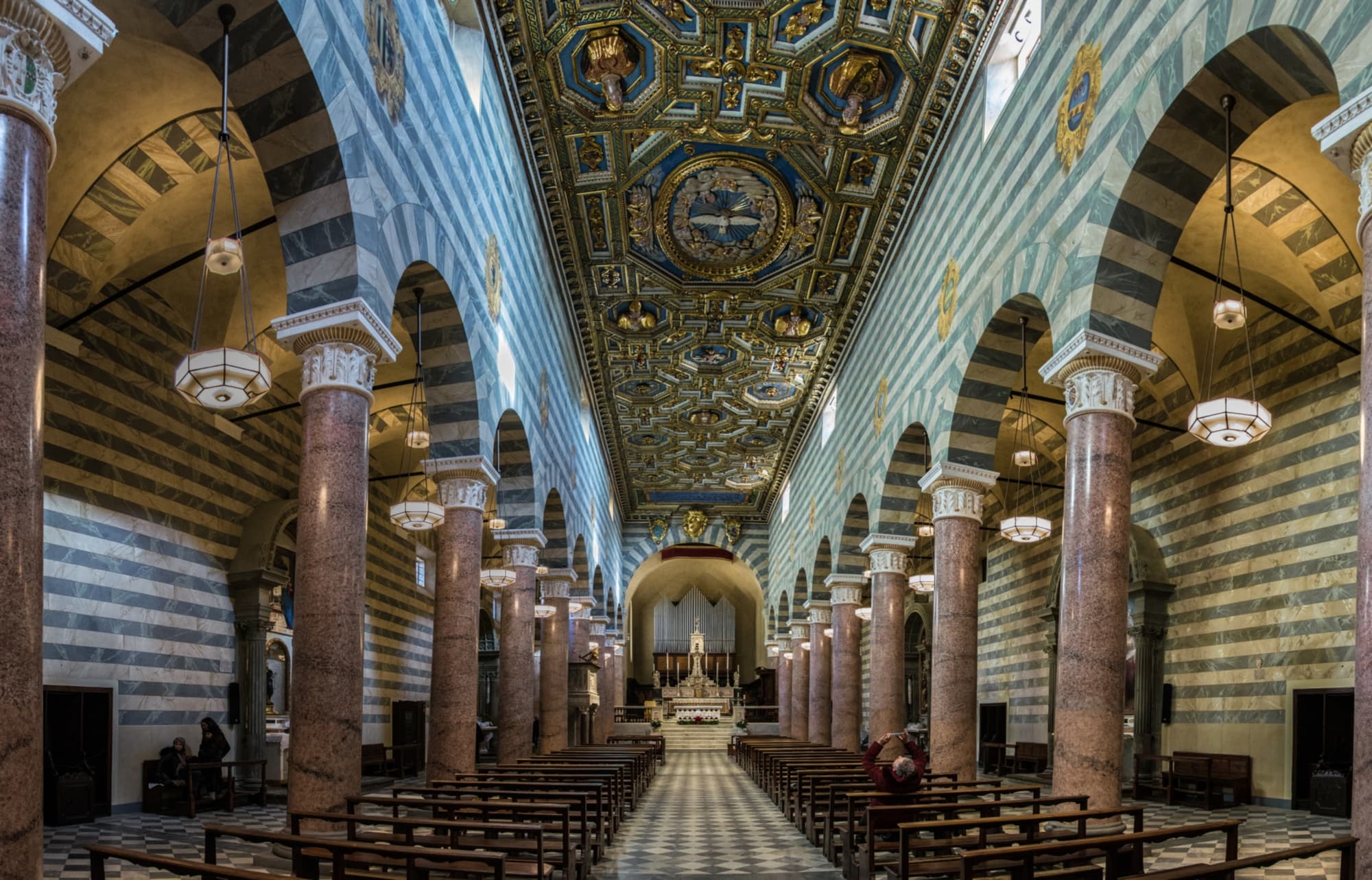 El interior de la Catedral de Volterra, con su característico artesonado dorado y las 21 columnas revestidas de estuco que simula granito rosa