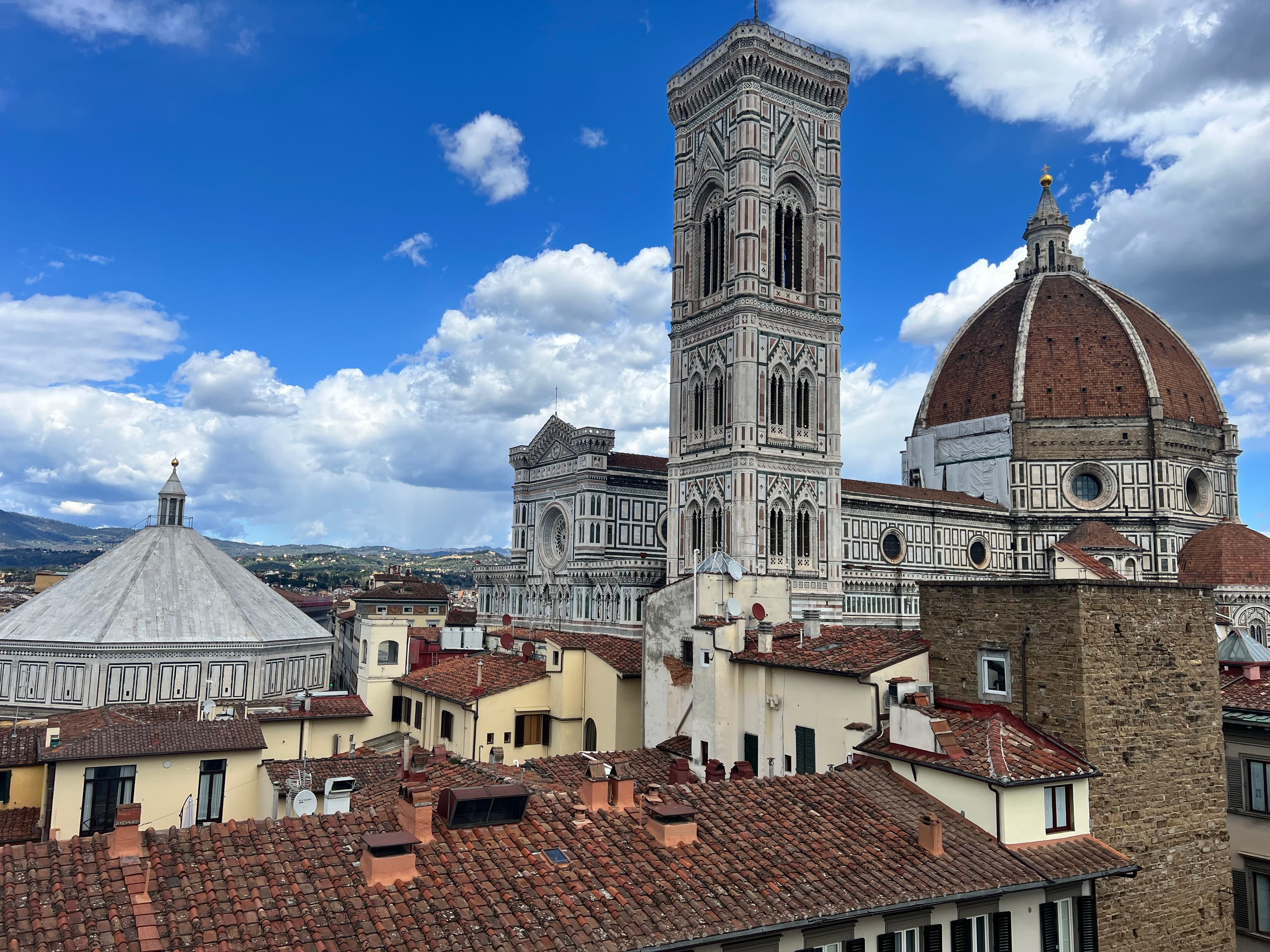 Vista sul Duomo di Firenze con la cupola del Brunelleschi, il Campanile di Giotto e il Battistero tra i tetti della città.