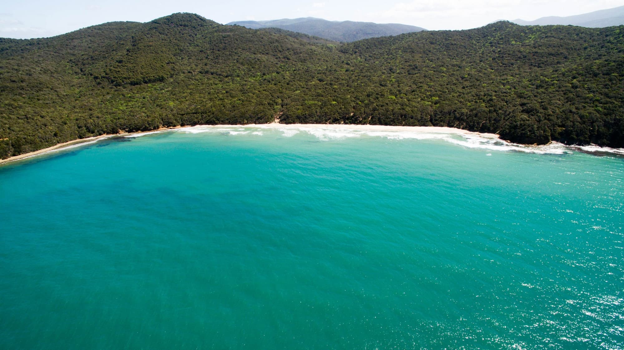 Vista aerea del mare di Cala Violina e sullo sfondo la Riserva Naturale delle Bandite di Scarlino.