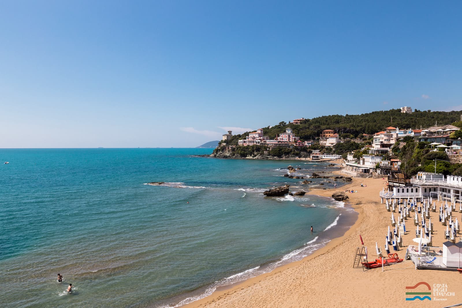 Vista aérea de la bahía del Quercetano, con la playa, sombrillas y gente en el mar