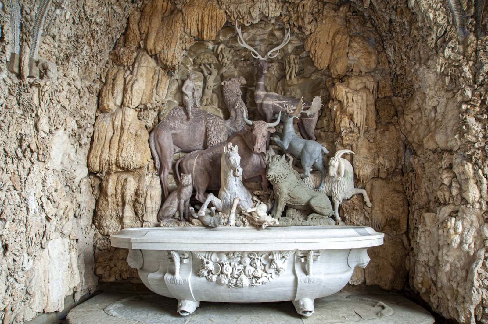 Nicho de la derecha de la Cueva de los Animales en la Villa Medicea de Castello. En el centro destaca un grupo escultórico compuesto por varios animales de mármoles de distintos colores, sobre una pila de mármol