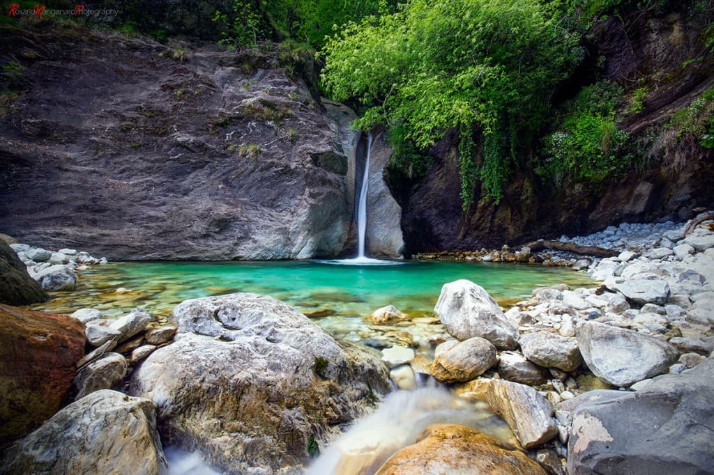 L’eau cristalline se jette entre les rochers entourés de verdure aux cascades de Malbacco.