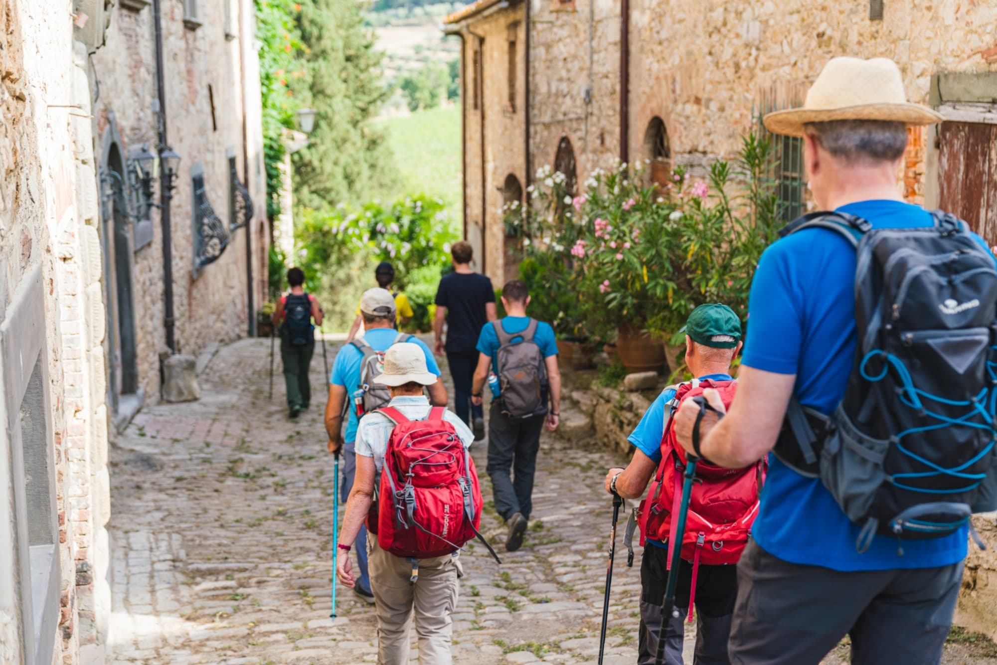 A group of people on a hike passing through a Chianti village
