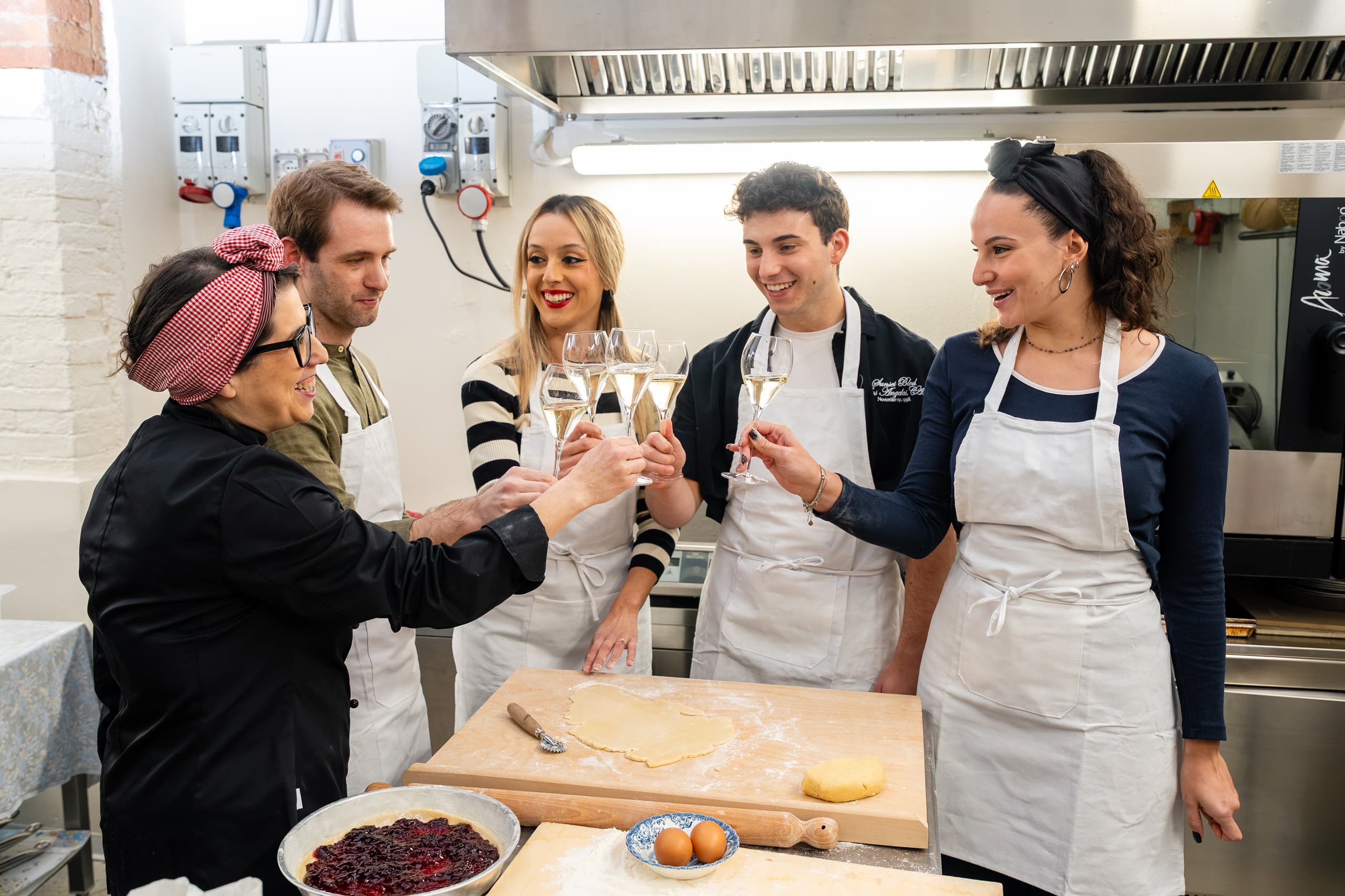 Chef and participants toasting in the kitchen during the cooking class