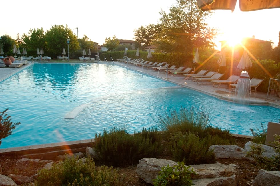 Piscine extérieure des thermes Antica Querciolaia à Rapolano au coucher du soleil.