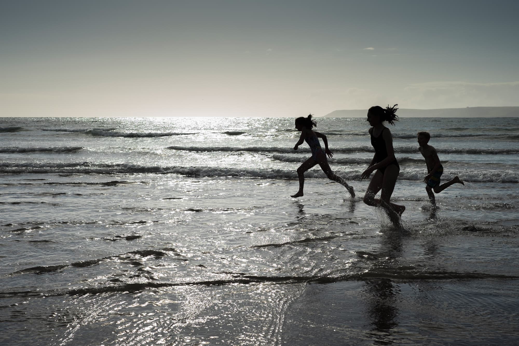 bambini che corrono in riva al mare