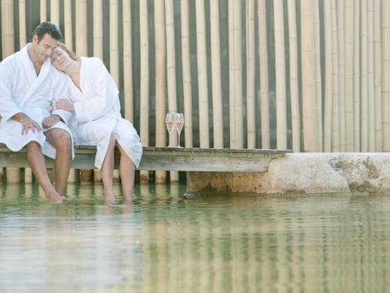 Pareja disfrutando de un momento de relax antes de un tratamiento cosmético con vino.