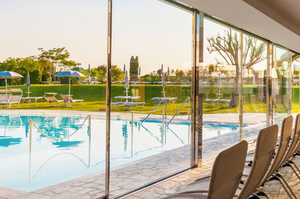 Les piscines de San Giovanni Terme Rapolano, avec salle de détente intérieure et chaises longues.