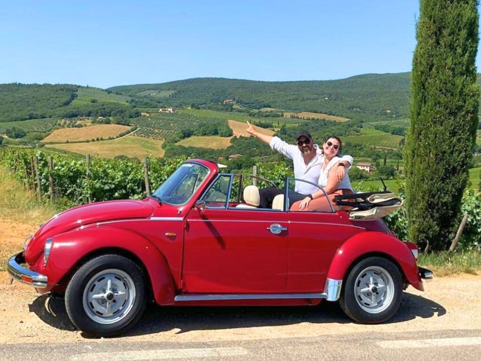 Vintage Volkswagen Beetle driving through Chianti hills