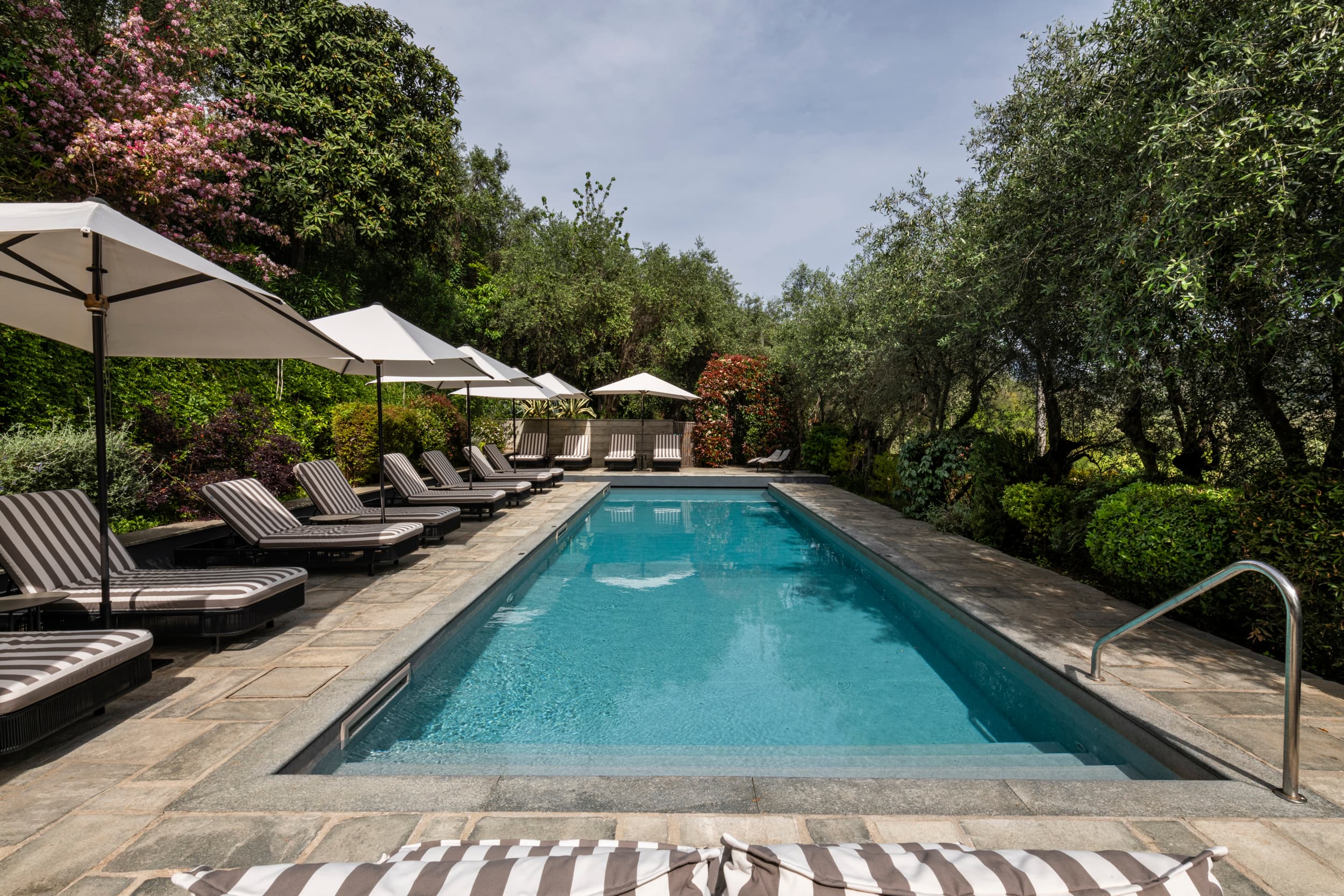 Piscina locanda al colle con ombrelloni e sdraio