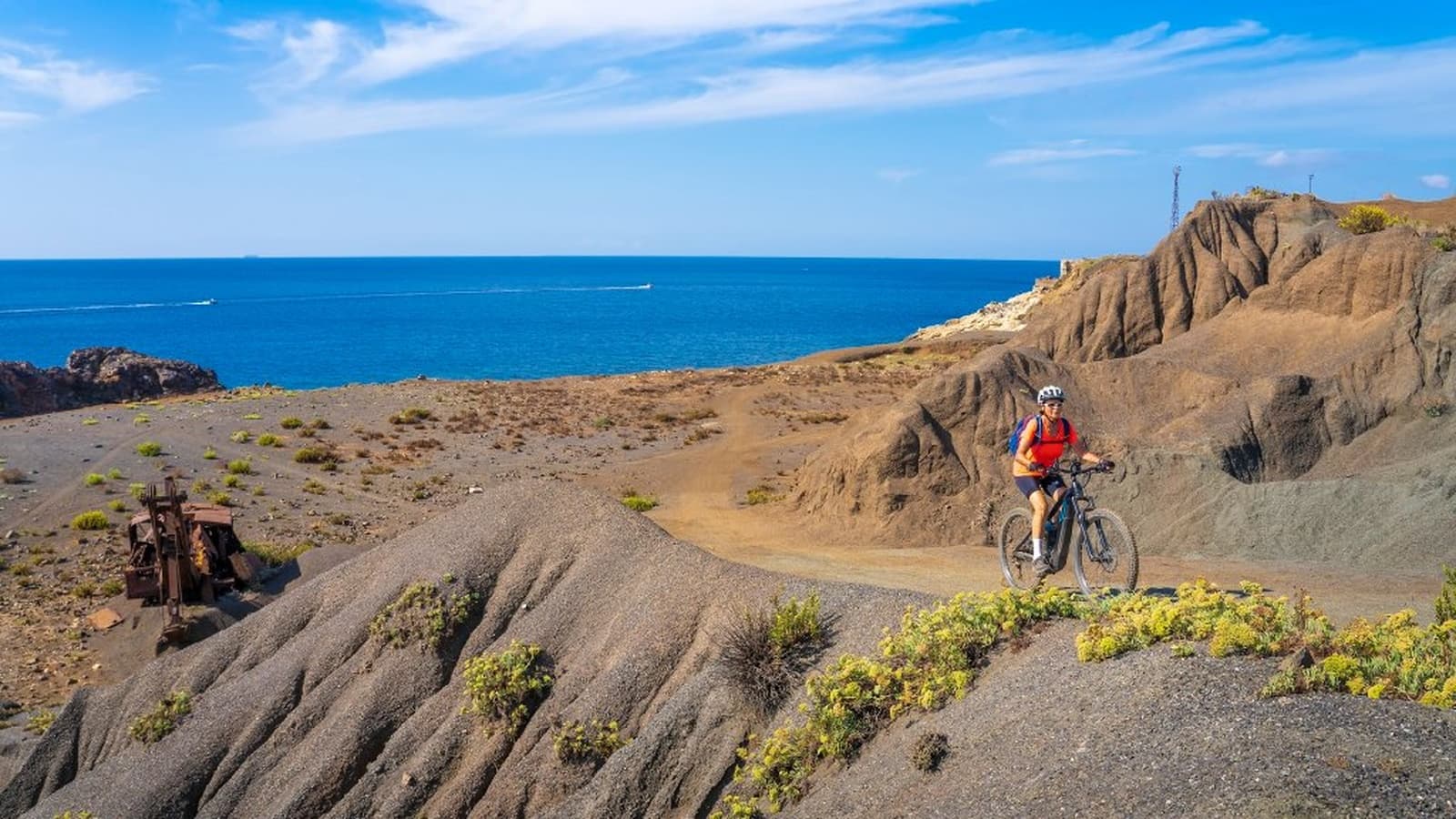 E-bike cyclist on dirt road with view of the bay and hills of Elba Island