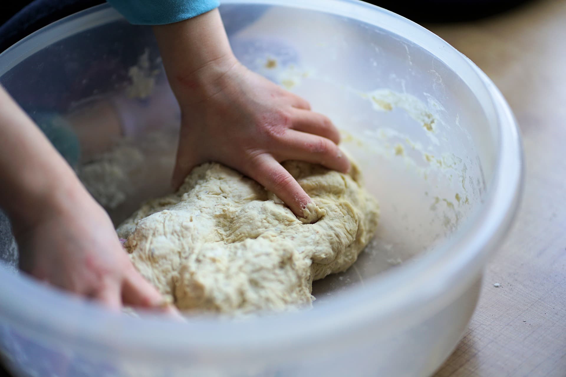 Mani di un bambino che impastano durante un laboratorio di cucina