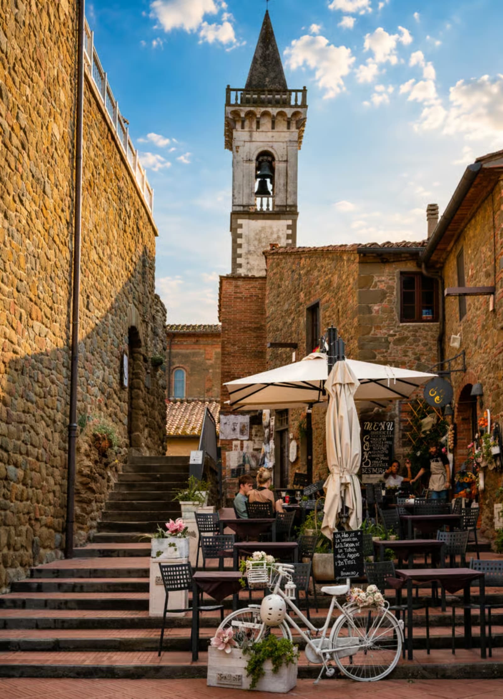 View of Vinci from the main square towards the church, with café tables and open umbrellas