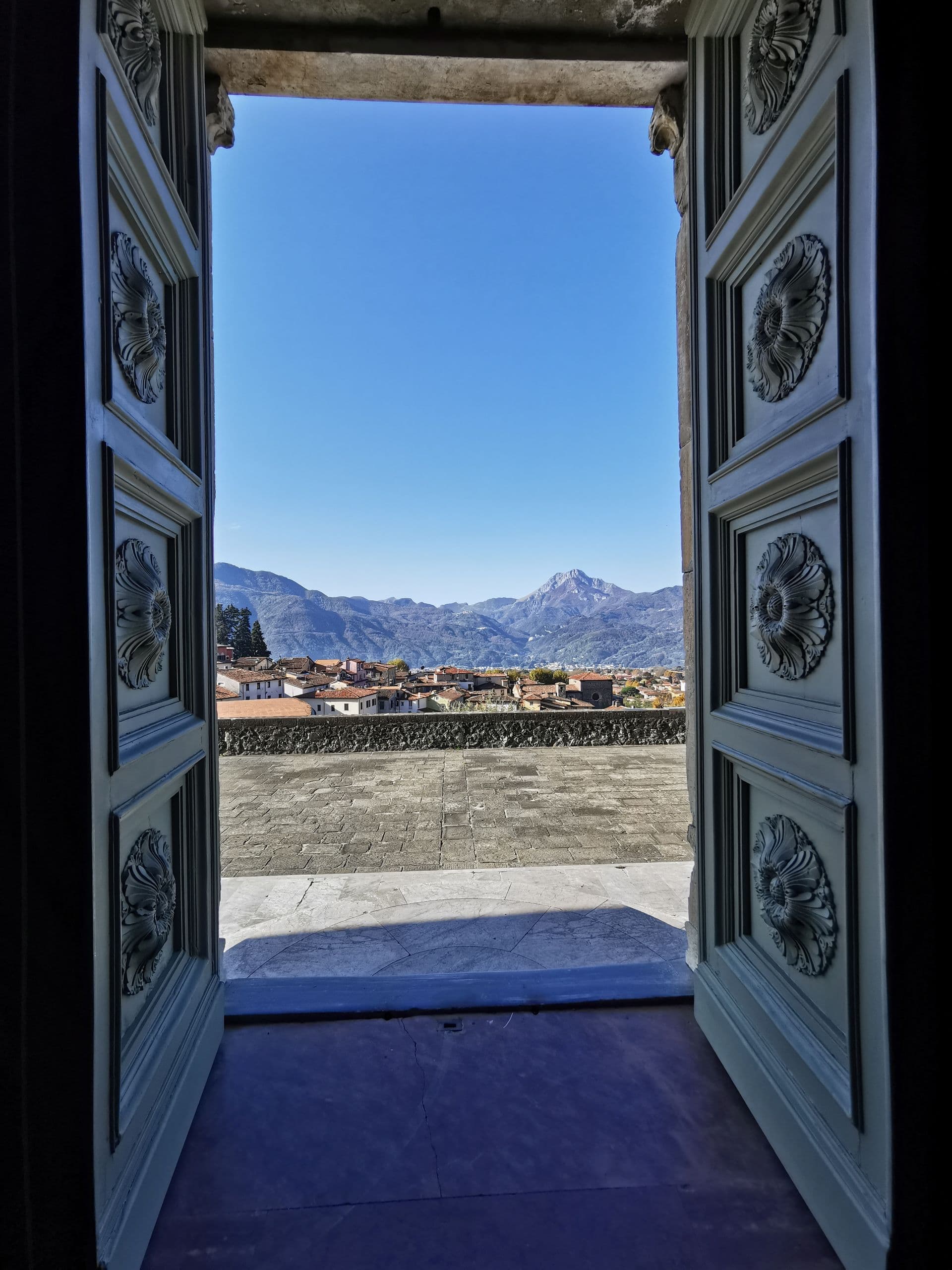 Panorama di Barga e le Alpi Apuane da un portone storico