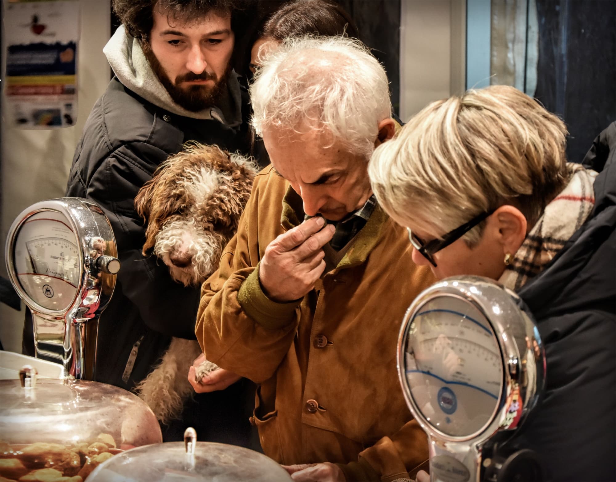Visitatori alla Mostra del tartufo bianco di San Miniato osservano e annusano i tartufi esposti su una bancarella