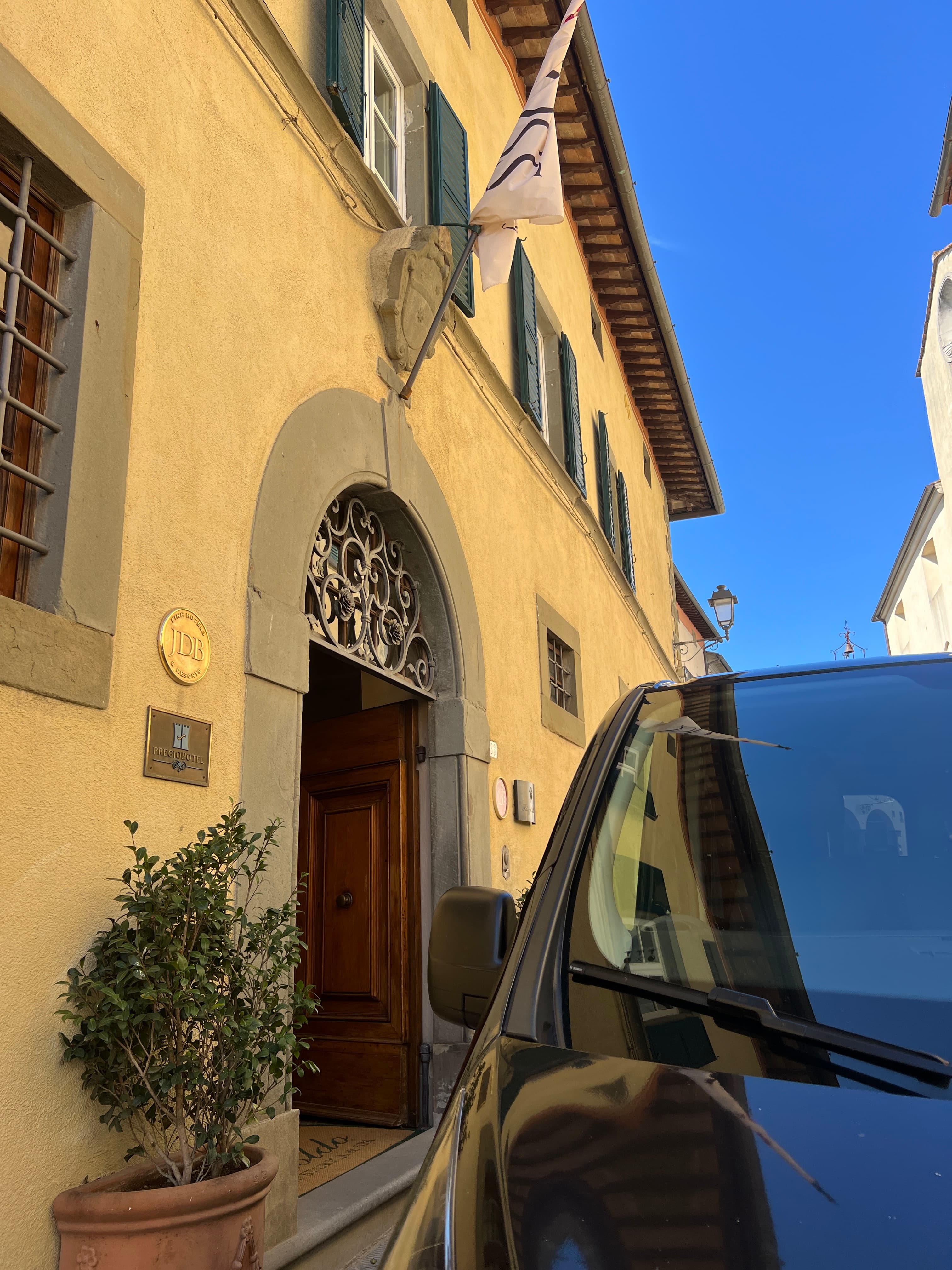 Un van privato attende i clienti davanti a un hotel immerso tra le colline del Chianti, pronto per accompagnarli in un tour tra cantine e borghi toscani.