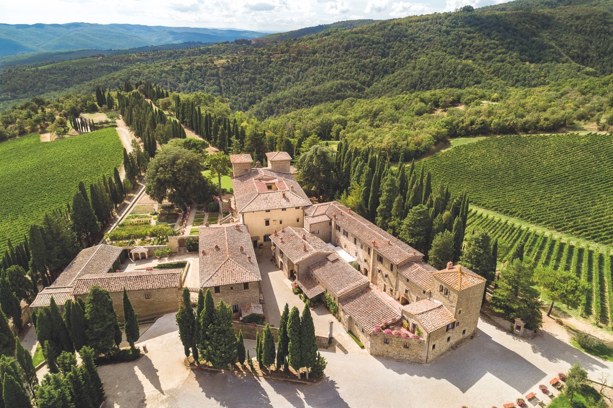 Vista del Castillo de Albola y del pueblo, rodeados de viñedos y de los bajos montes del Chianti