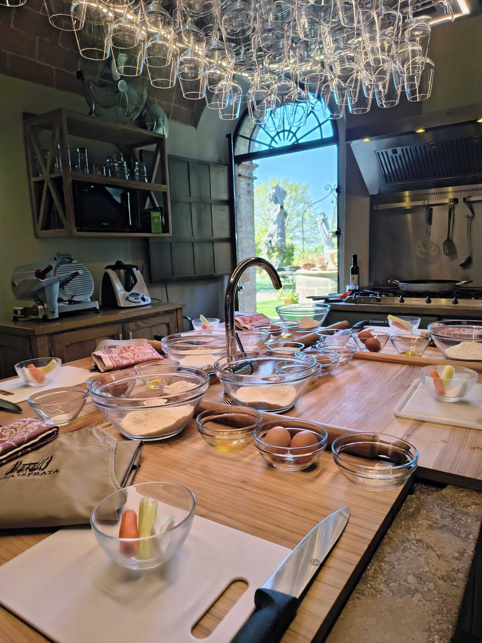 Cooking class toscana con ingredienti freschi, utensili e postazioni individuali a Montalcino.