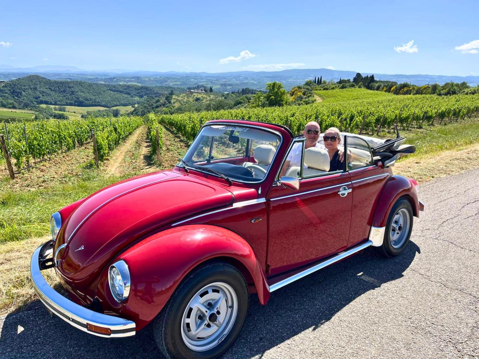 Vintage Volkswagen Beetle driving through Chianti hills