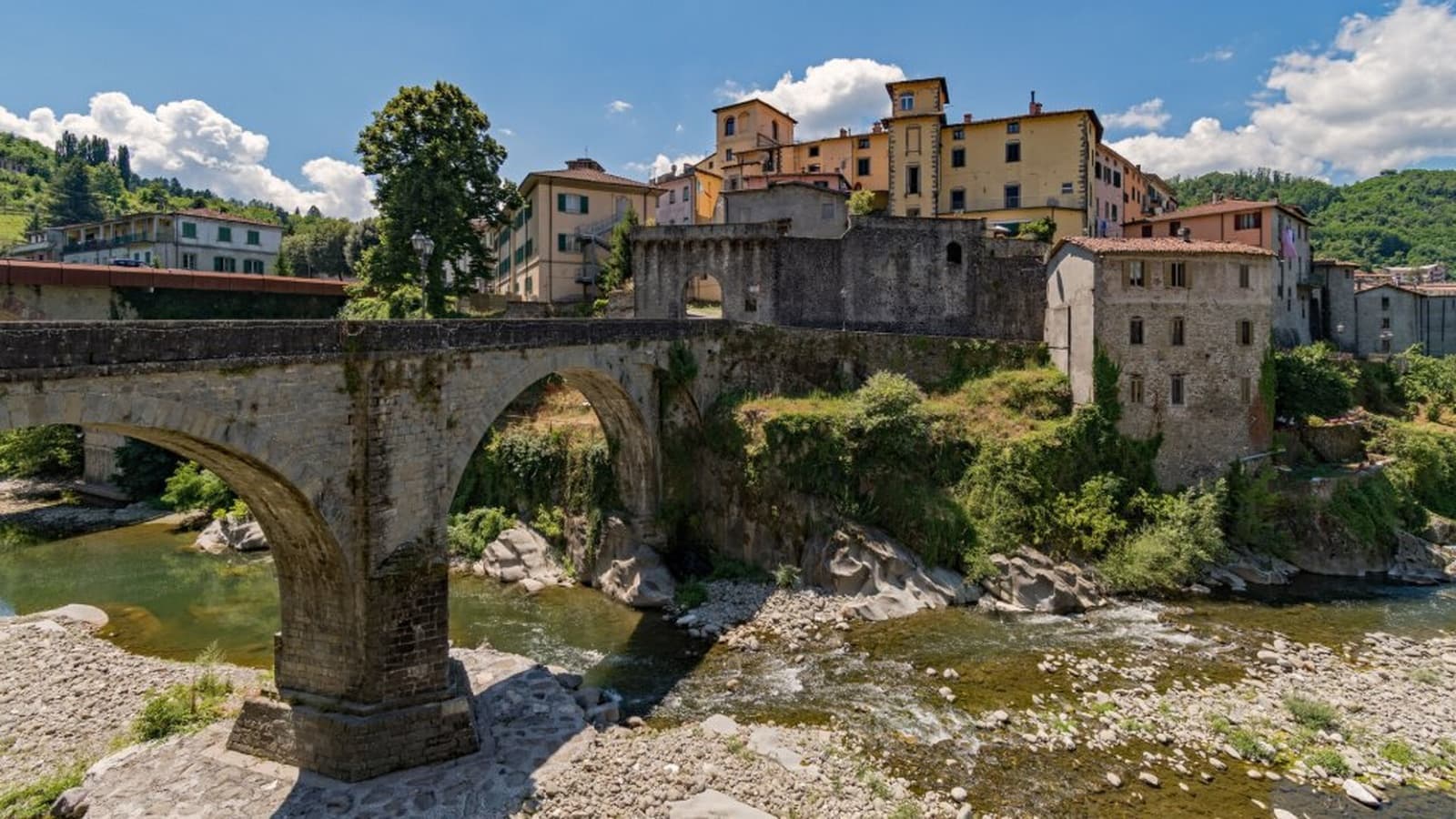 Castelnuovo di Garfagnana, the medieval bridge over the Serchio River with the old town in the background