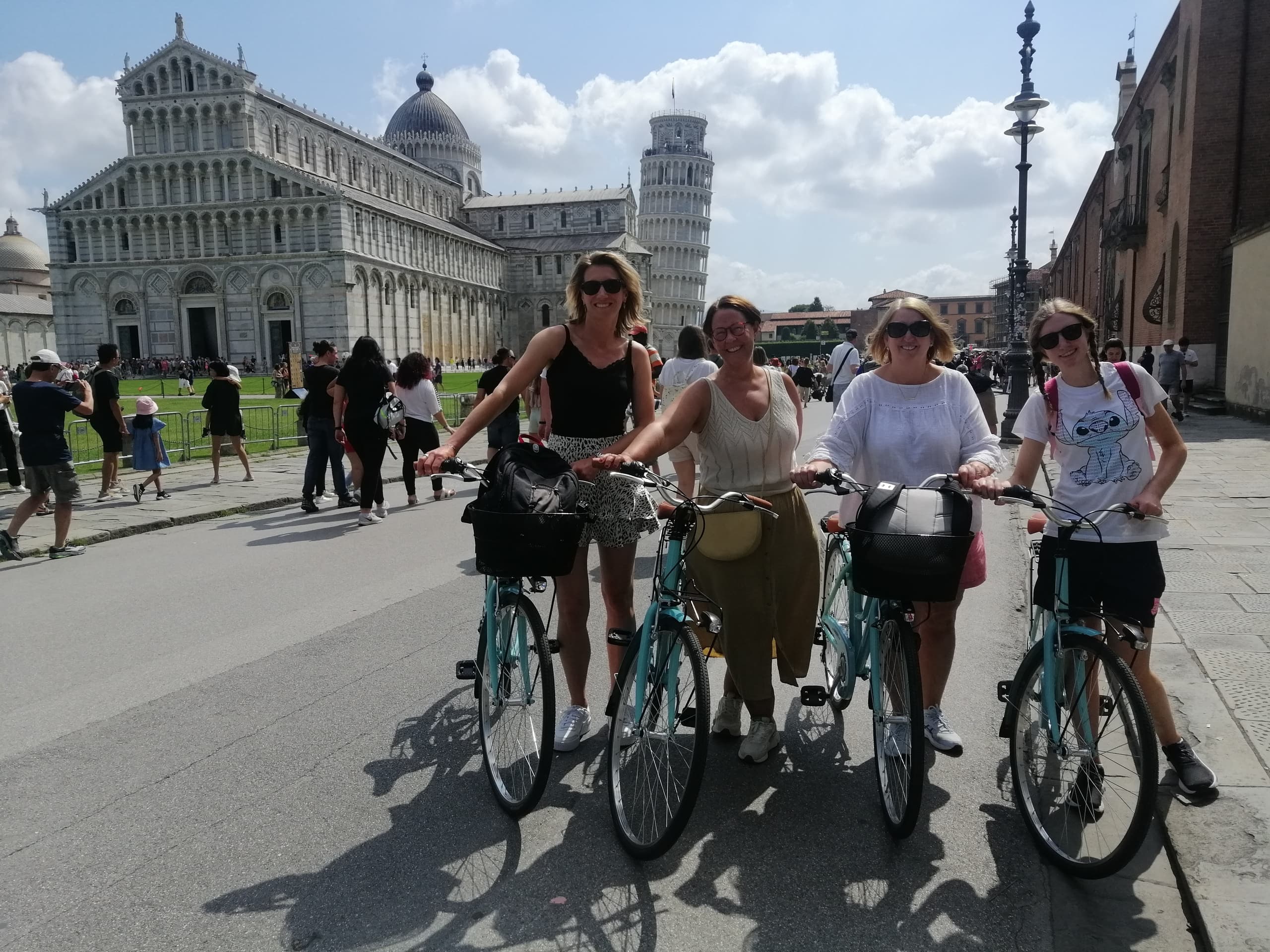 Gruppe von Personen mit Fahrrädern auf der Piazza dei Miracoli